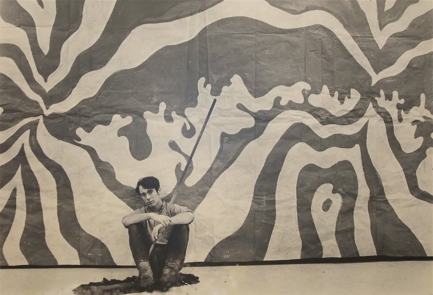    A young Gordon Carlisle in front of one of his first murals, ca. 1968 (Photo: Robert Carlisle)